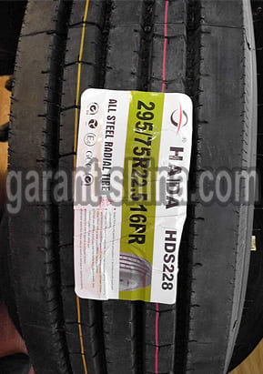 Haida HDS228 (рулевая) 295/75 R22.5 146/143M 16PR - Фото протектора с этикеткой вблизи